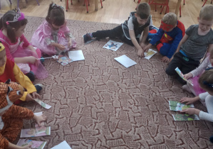 Dzieci oglądają ilustracje z postaciami z bajek
